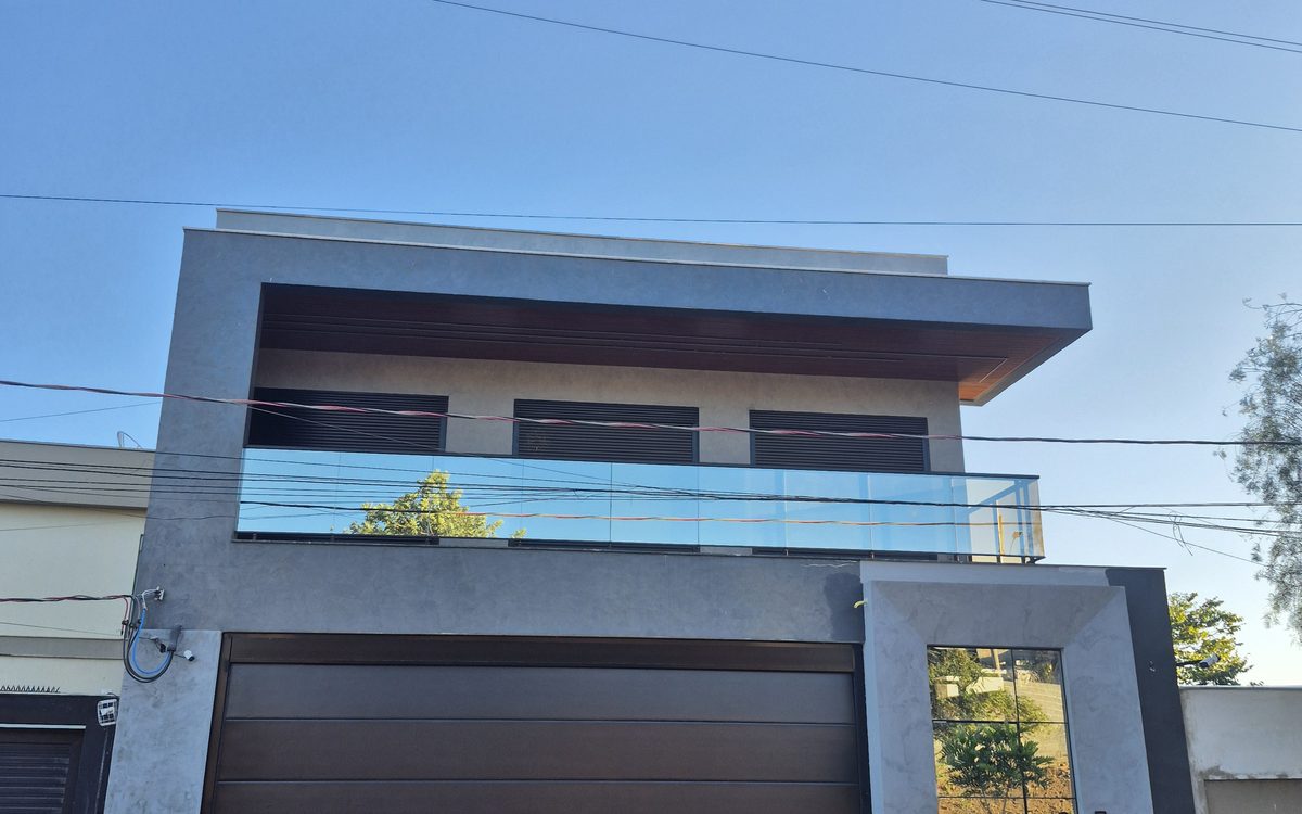 Fachada da Residência Deck 519 — sobrado de alto padrão em concreto aparente, vidro e madeira